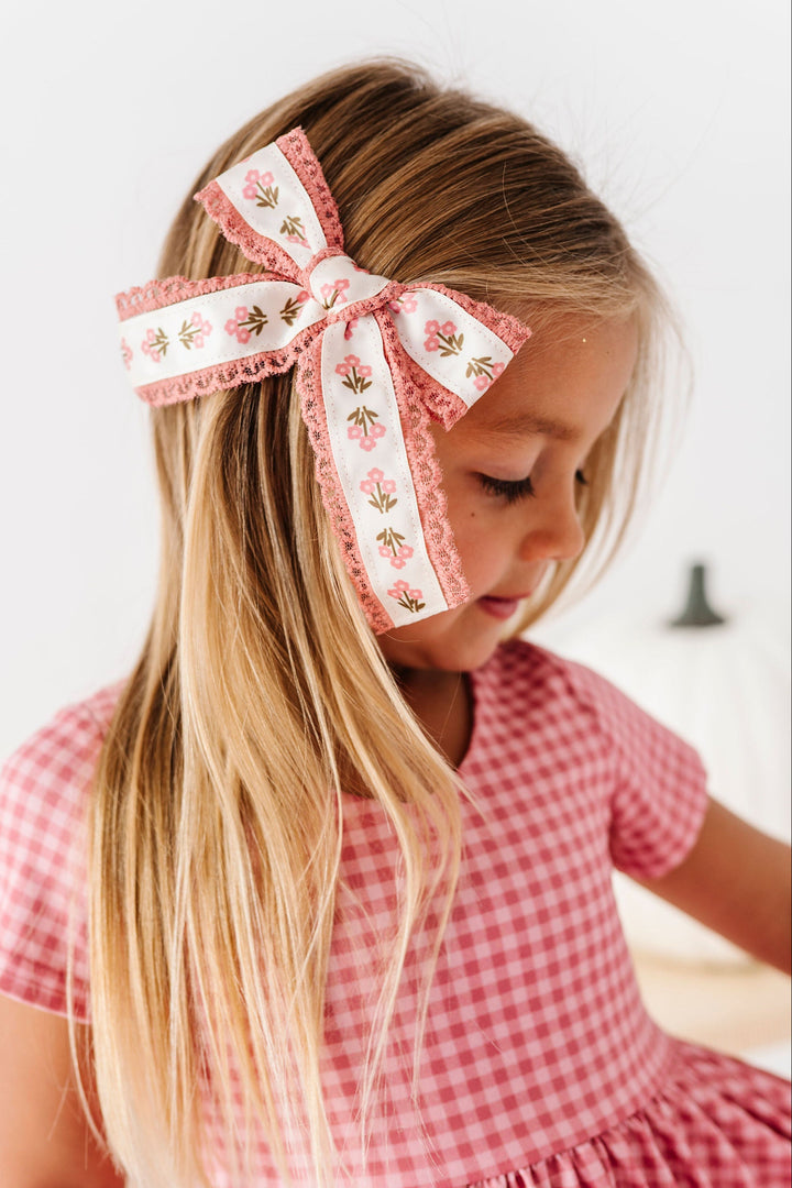 little girl wearing pink and ivory lace floral hair bow