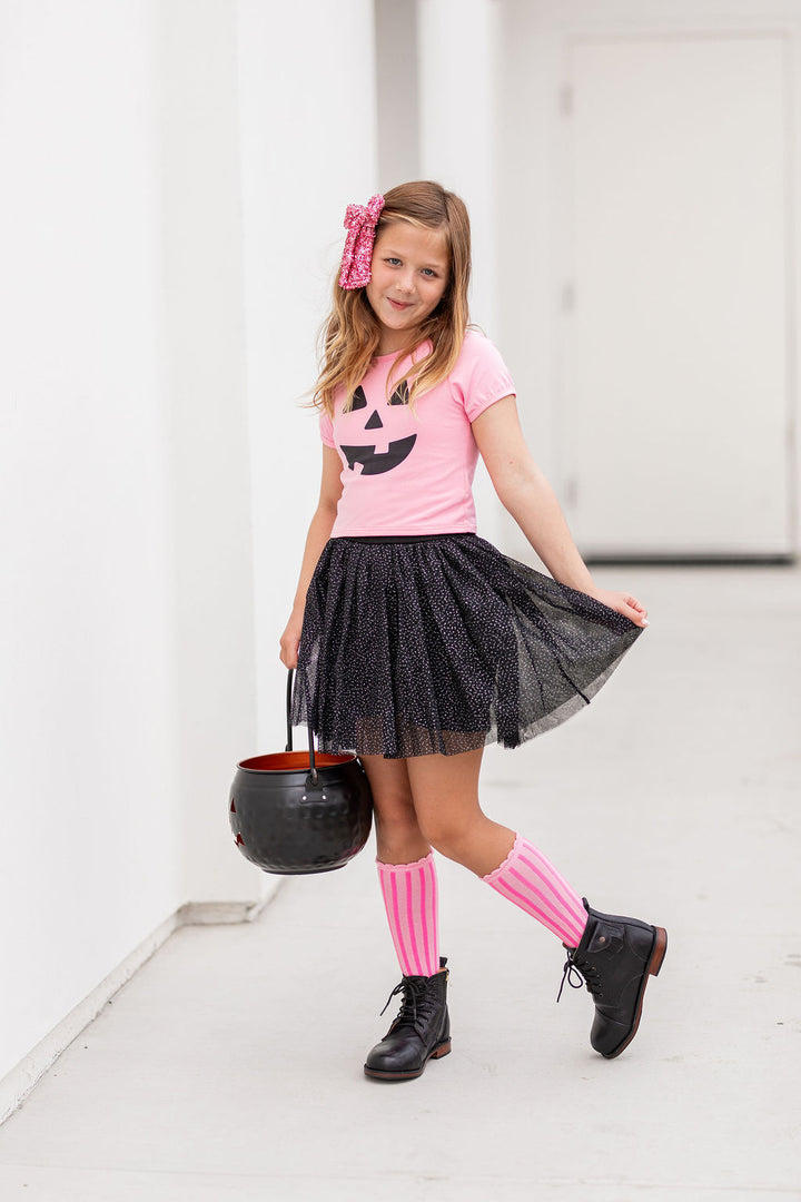 little girl in pink pumpkin top and sparkly black tutu skort with matching pink accessories