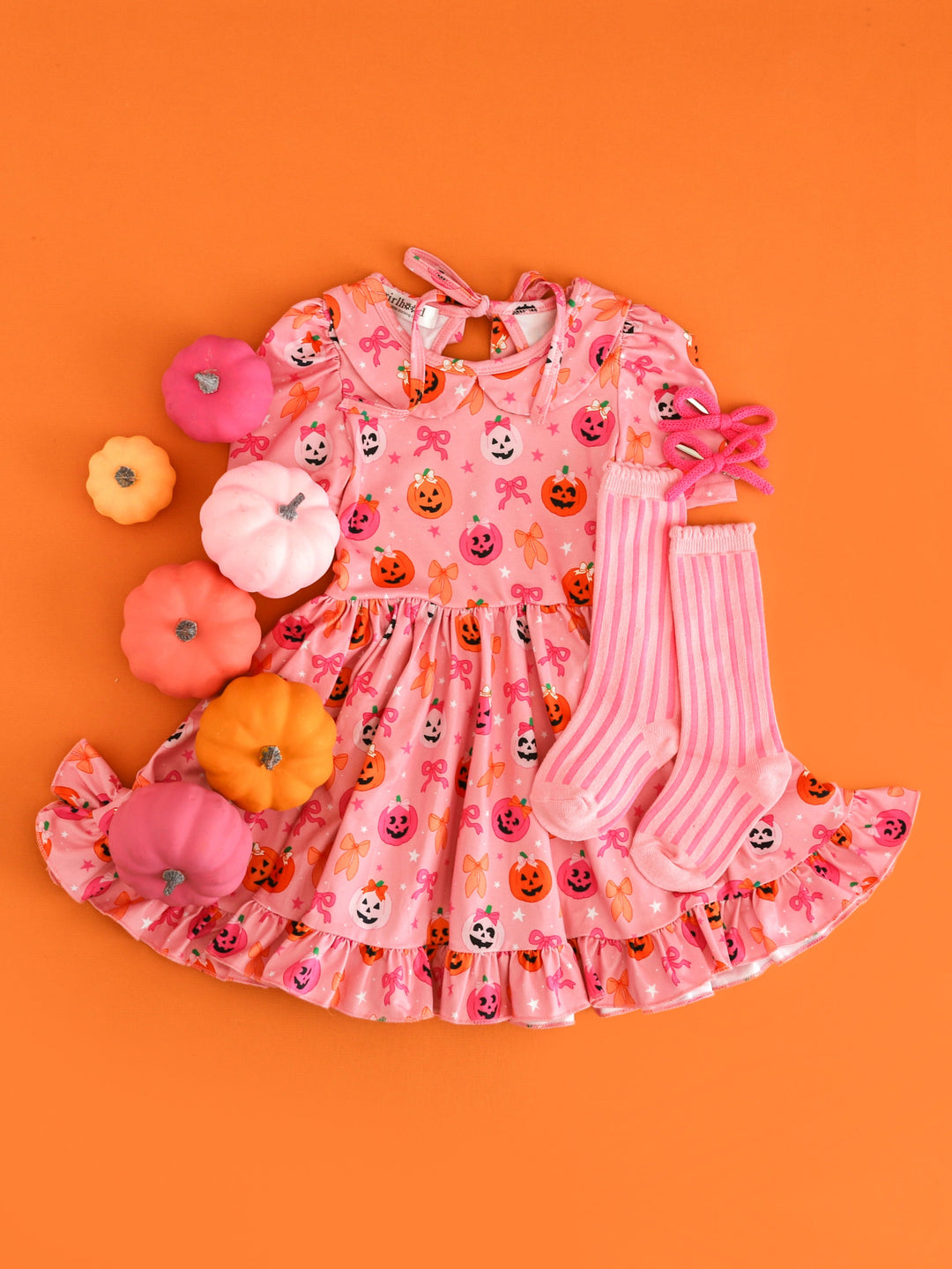 girl's pink short sleeve collared twirl dress with pumpkin and bow design paired with pink accessories 
