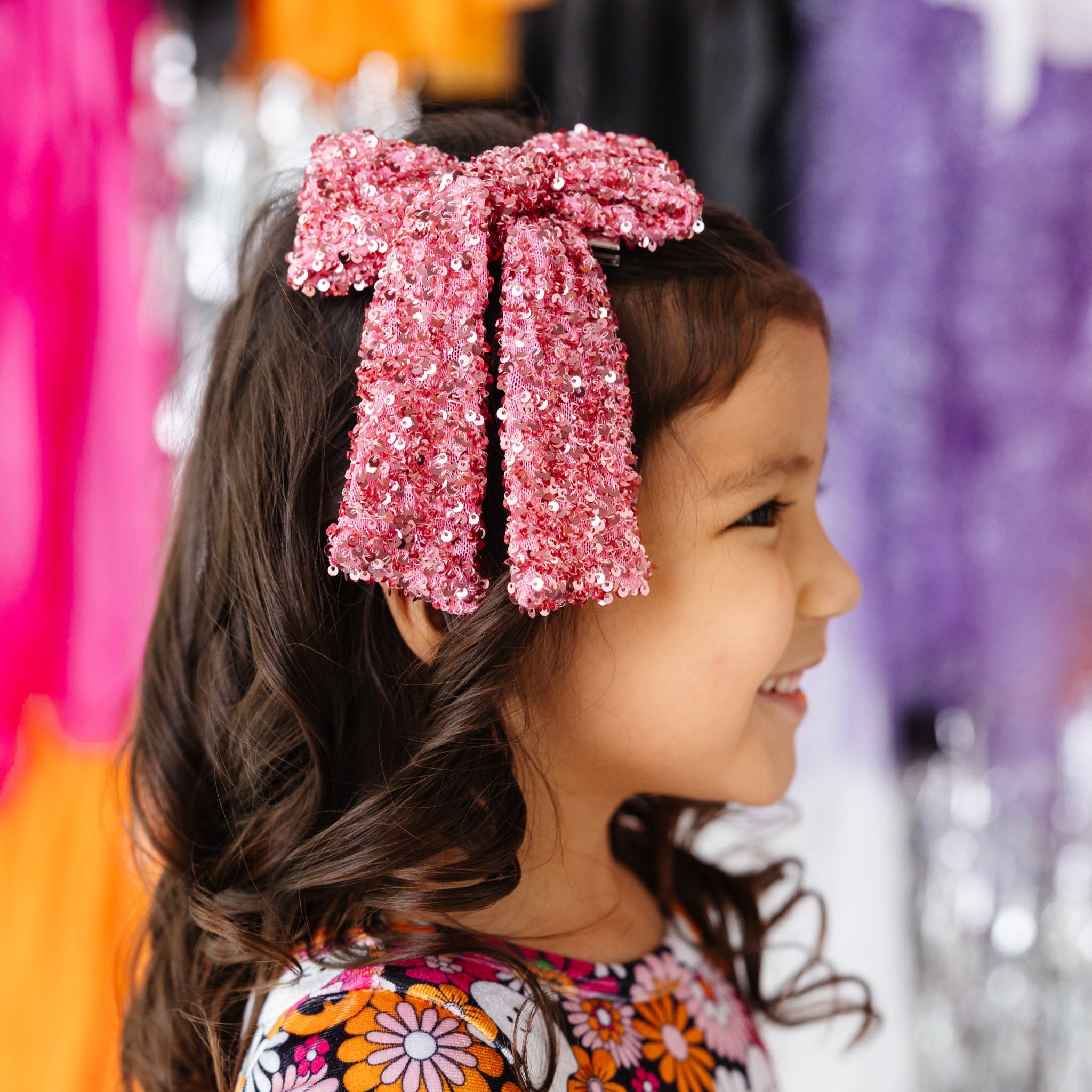 little girl in pink bow with sparkly pink sequins paired with long sleeve velvet twirl with Halloween themed floral print