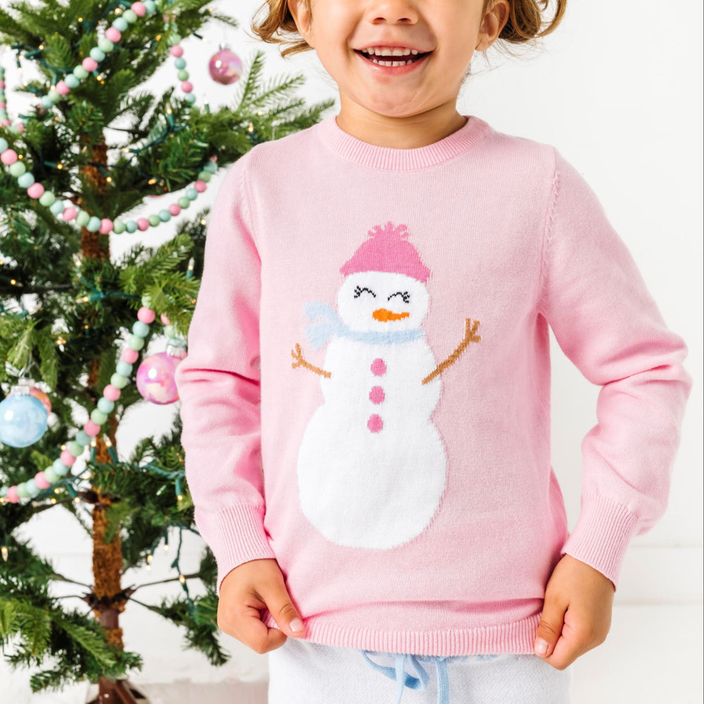 little girl in pink cotton knit sweater with snowgirl design for winter