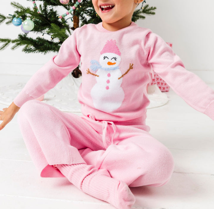 little girl in pink snowgirl pullover sweater and matching pink sweater pants for Christmas