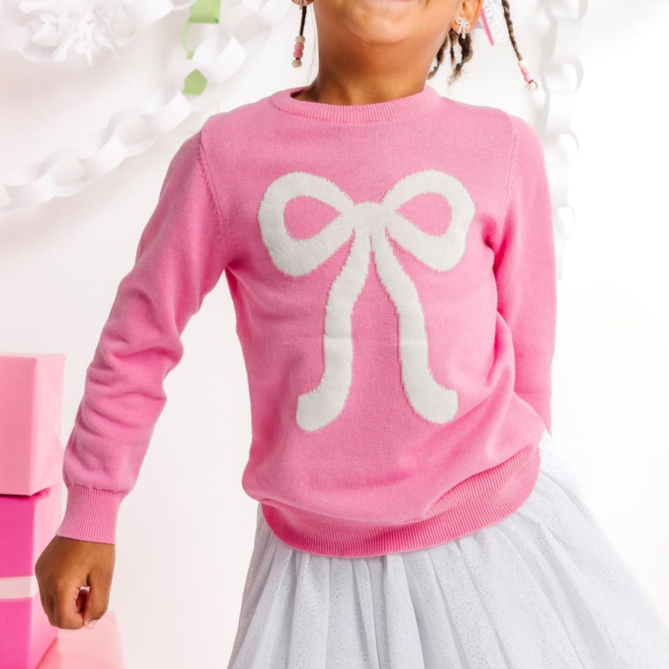 girl in pink pullover sweater with white sparkly bow design and matching white sparkle tutu skirt