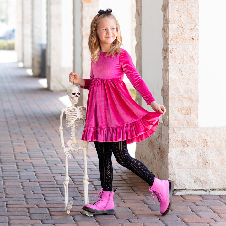 girl wearing pink velvet dress with black pointelle knit tights