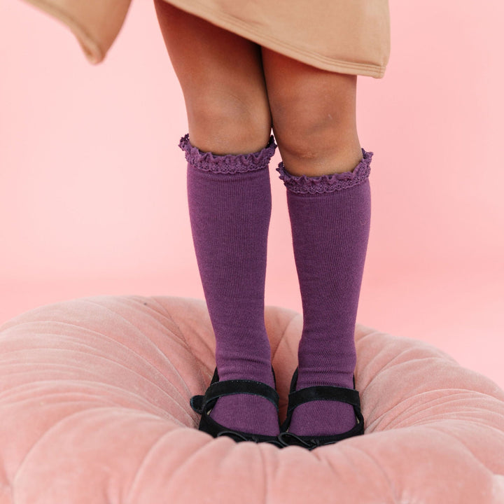 little girl wearing plum purple lace top knee socks