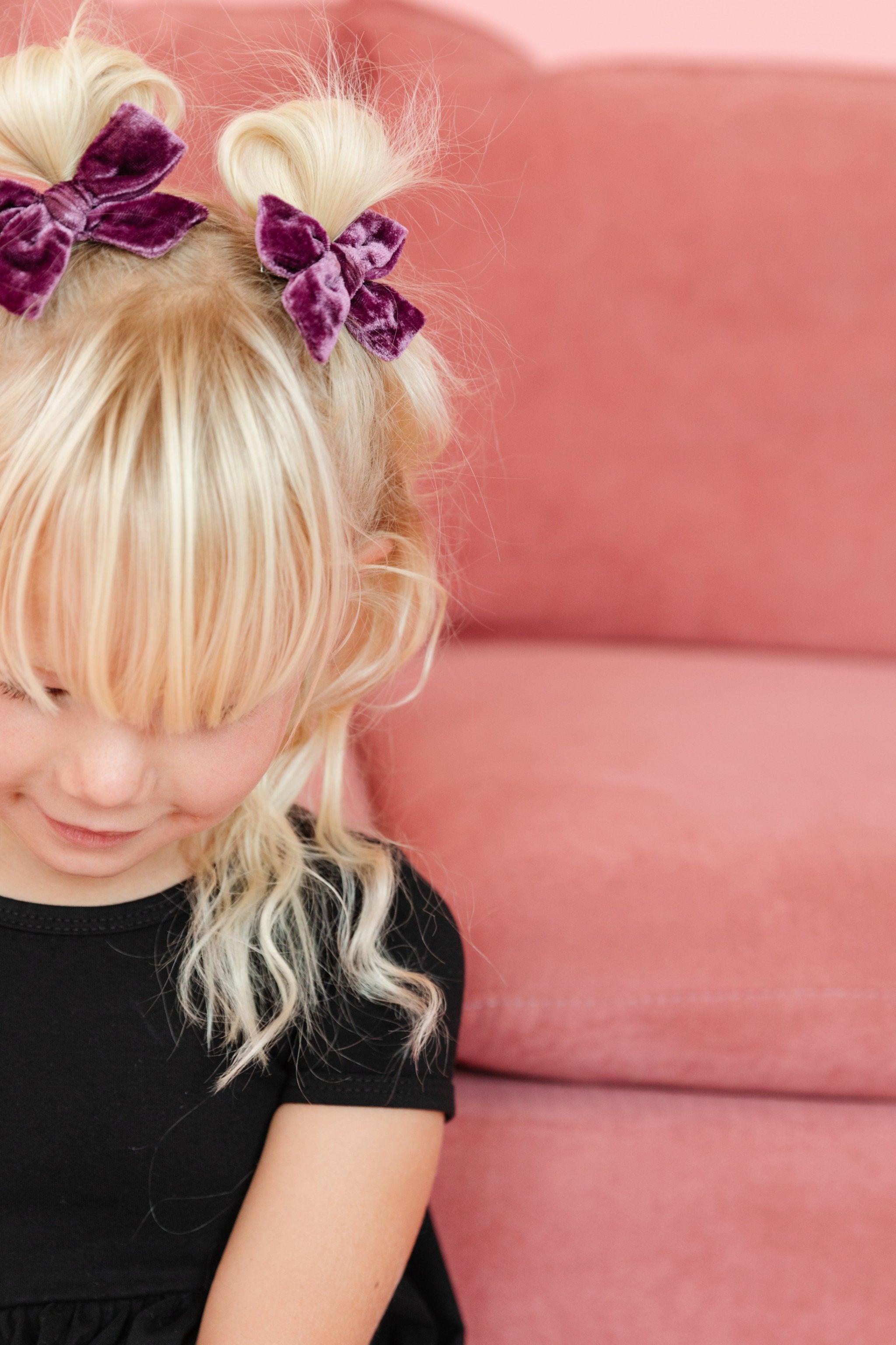 little girl in black twirl dress for fall with dusty purple velvet pigtail bows