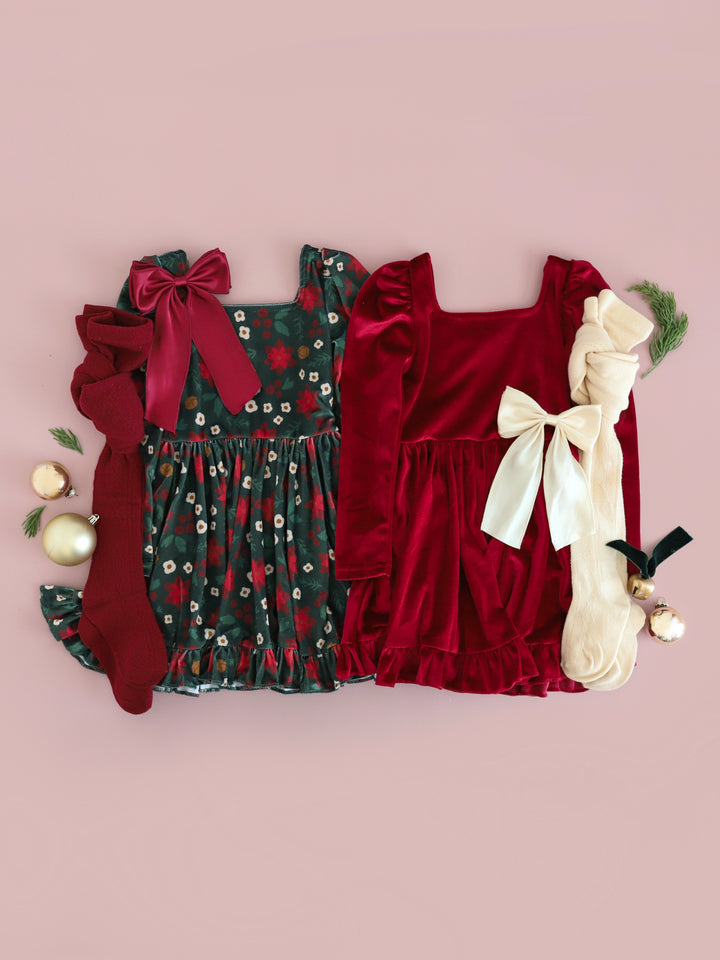 girls vintage inspired forest green poinsettia velvet and crimosn velvet long sleeve twirl dresses for Christmas with matching open knit tights and satin bows