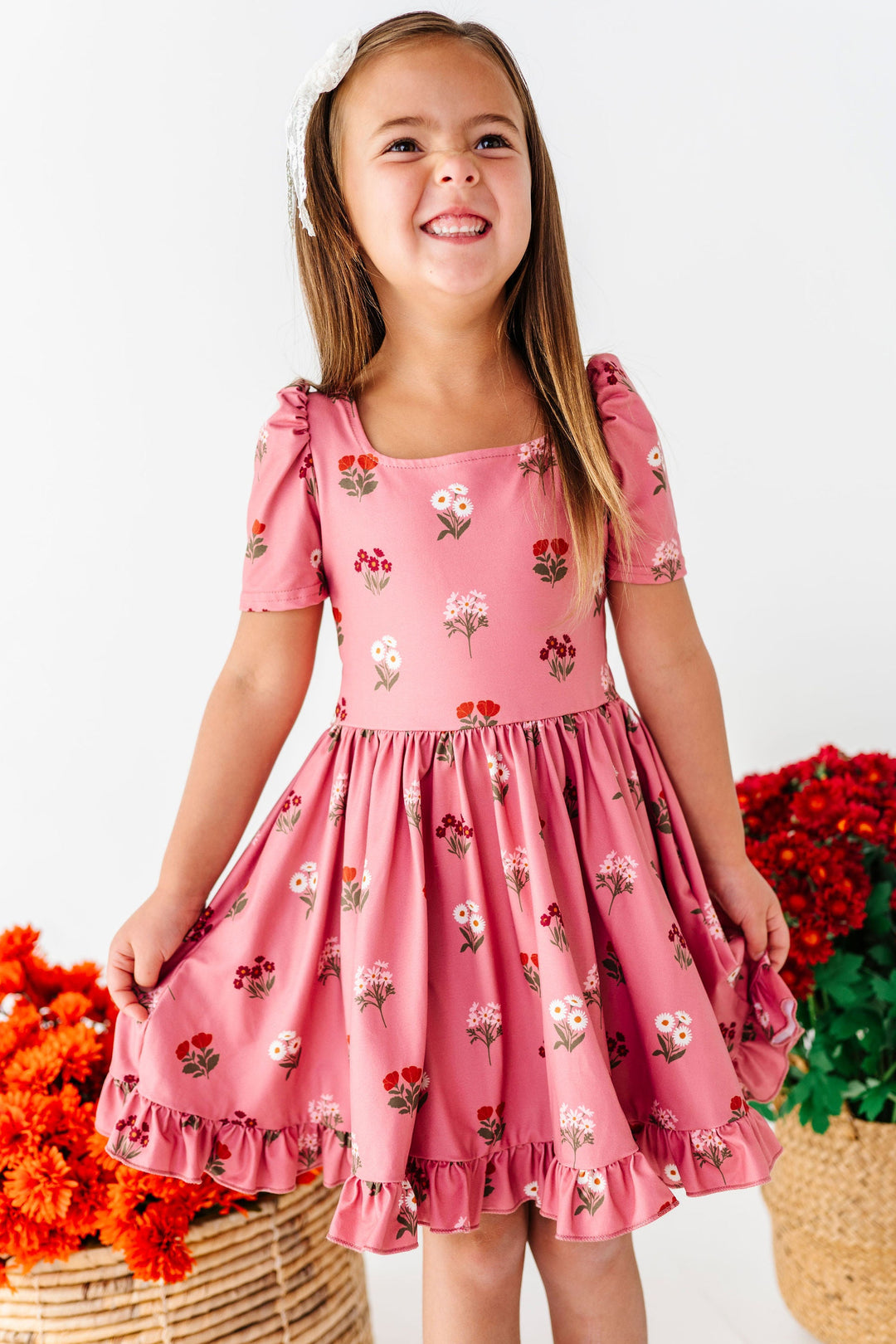 girl wearing pink twirl dress with fall bouquets