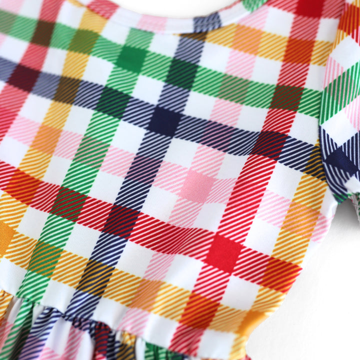 closeup of gingham print school dress bodice in red, yellow, blue, green and pink on white