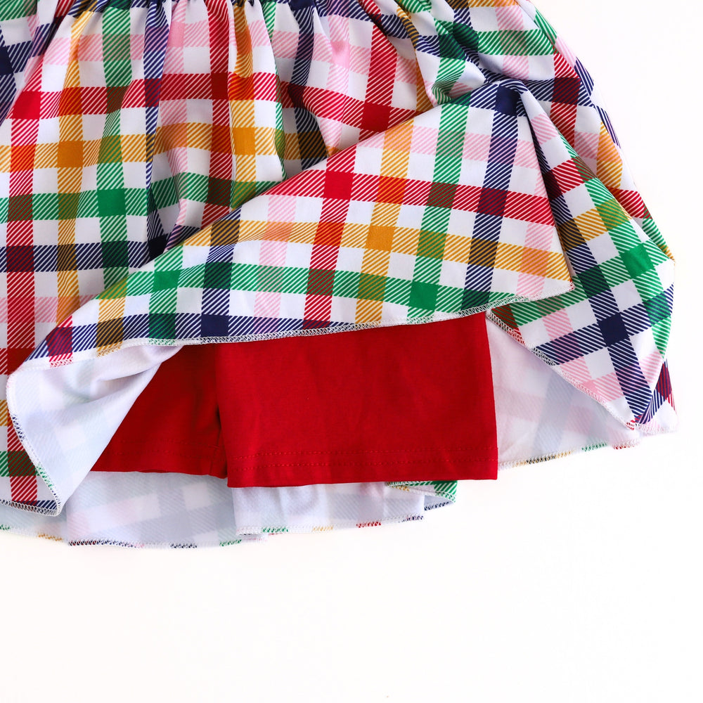 closeup of built-in bright red stretchy shorts attached to primary gingham skort