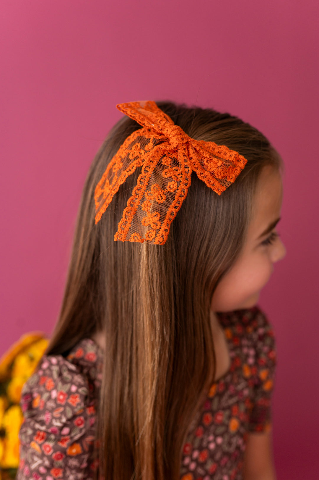 young girl in brown floral twirl dress paired with pumpkin spice lace fall bow