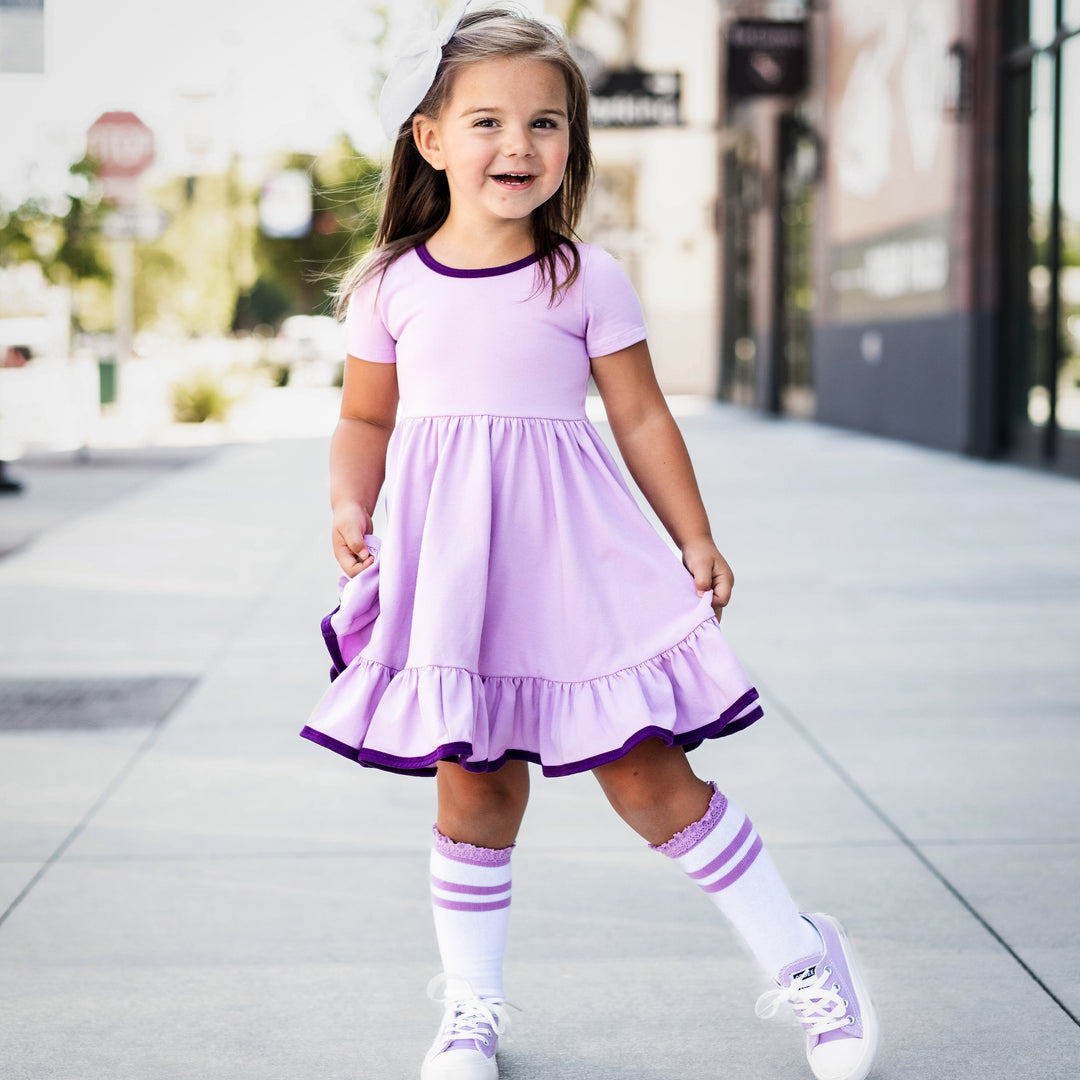 little girl in purple twirl dress and matching white and purple lace trimmed knee high socks