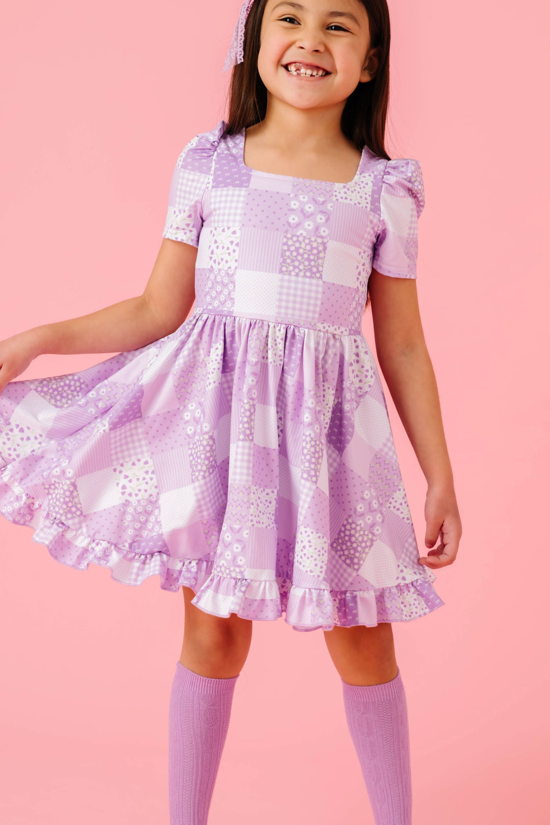 girl in patchwork print twirl dress paired with matching purple cable knit knee socks