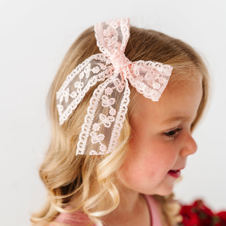 little girl in soft pink lace bow on alligator clip