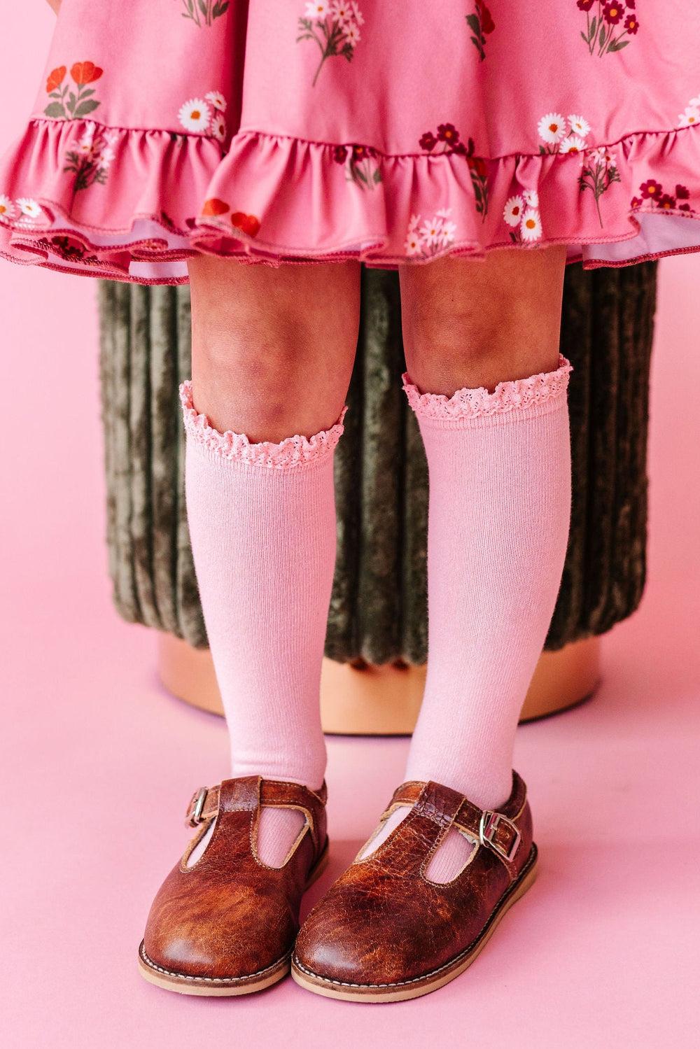 girl wearing pink lace trim knee high socks with matching pink dress