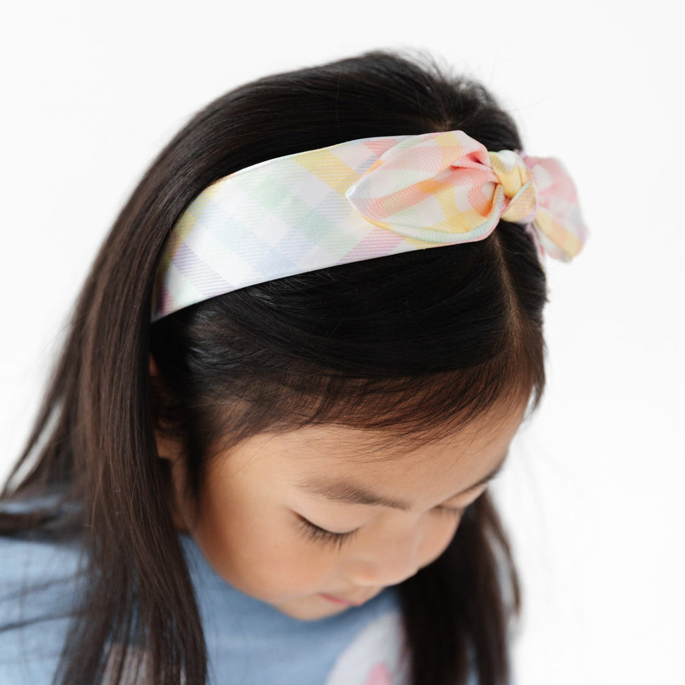 girl wearing satin headband with knotted bow detail in pastel gingham print for spring and easter