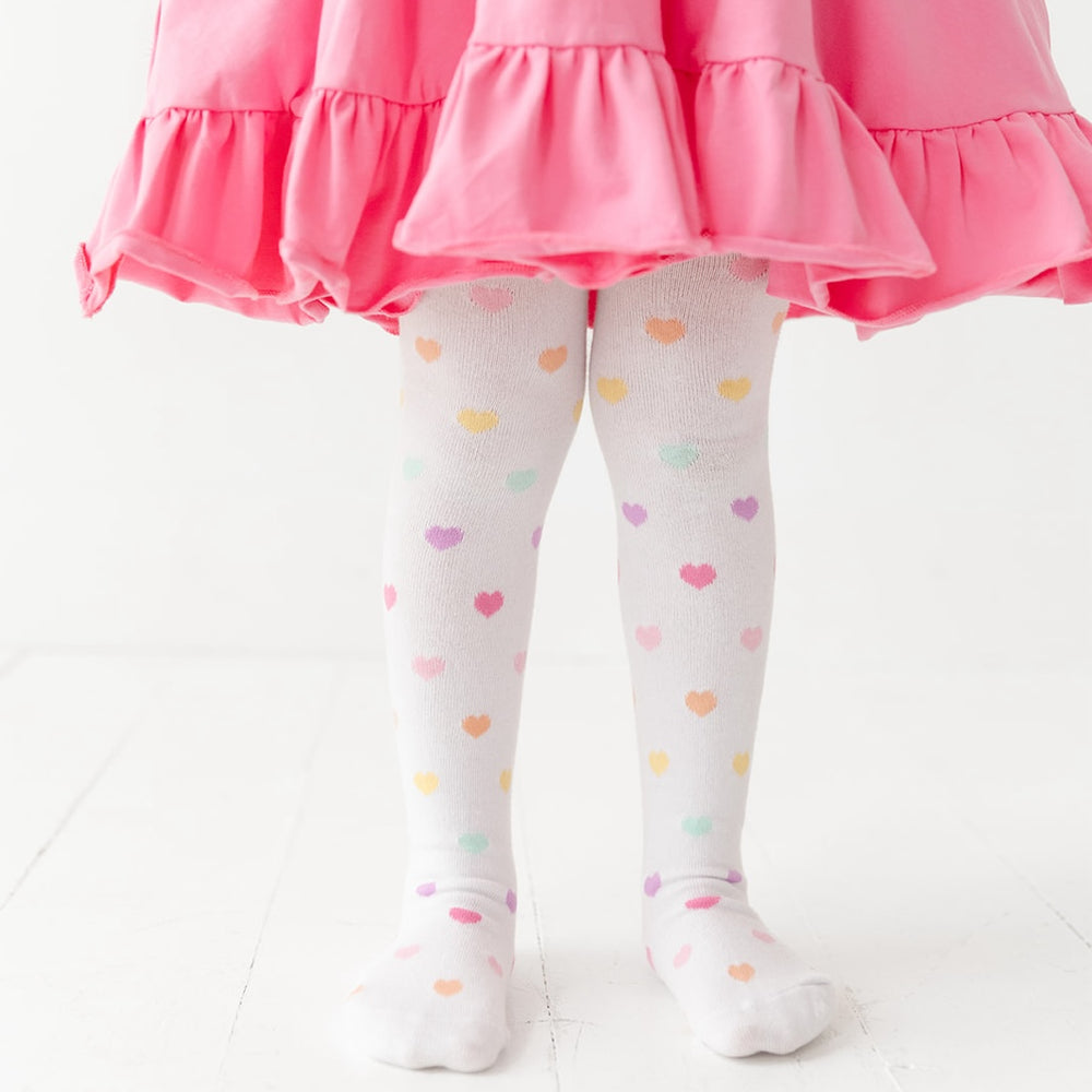 little girl wearing rainbow heart knit tights