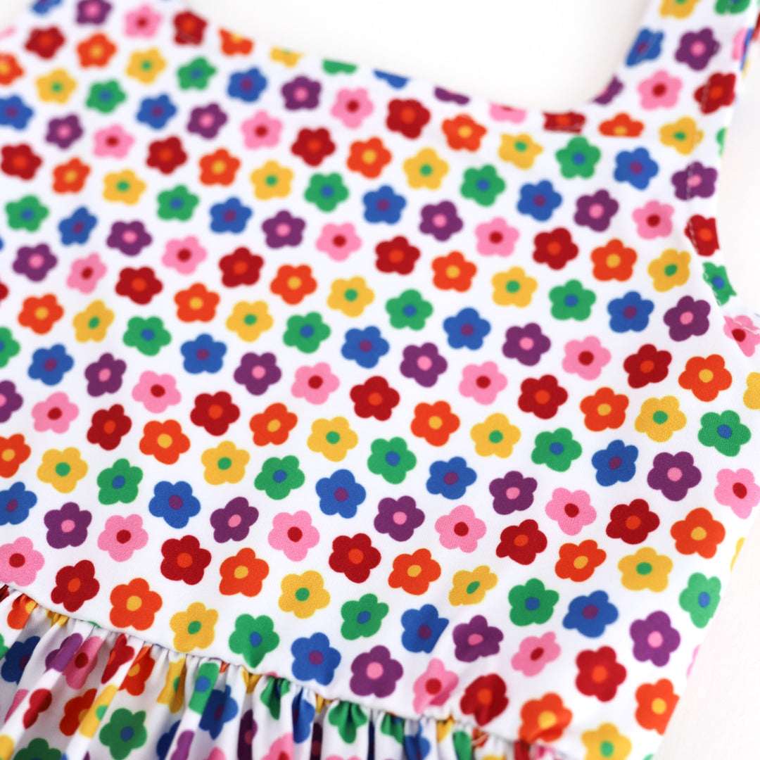 detail photo of retro flowers in every color of the rainbow on little girls' twirl dress