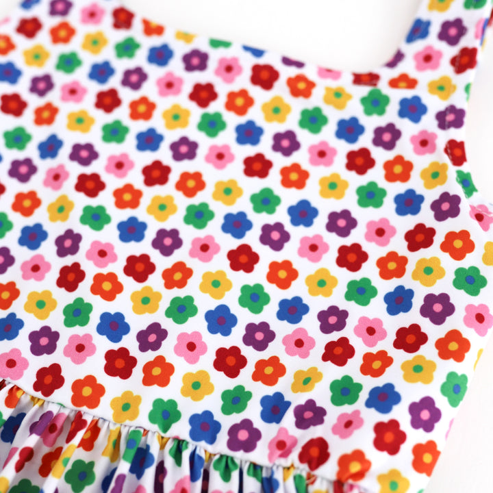 detail photo of retro flowers in every color of the rainbow on little girls' twirl dress