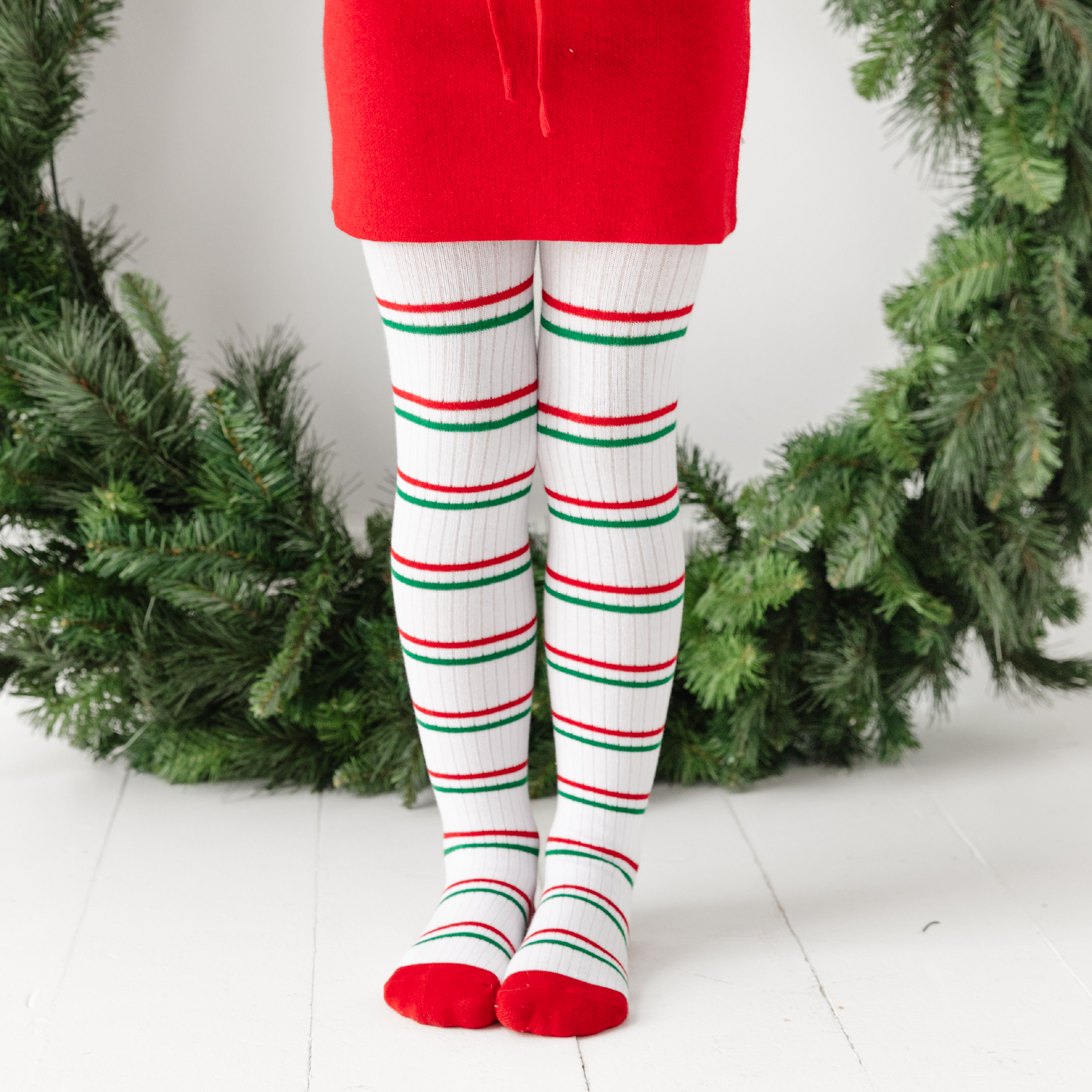 girl in ribbed christmas stripe tights with red toes