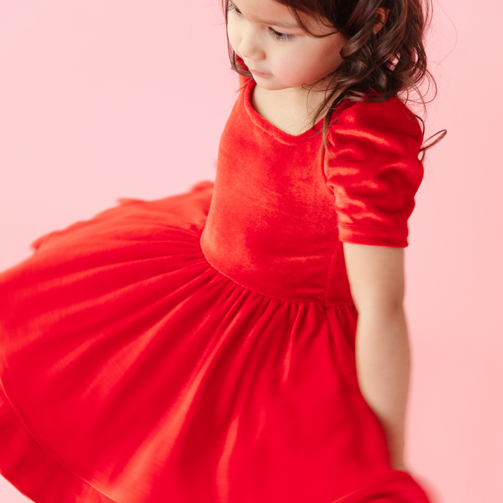 girl twirling in red velvet square neck occasion dress