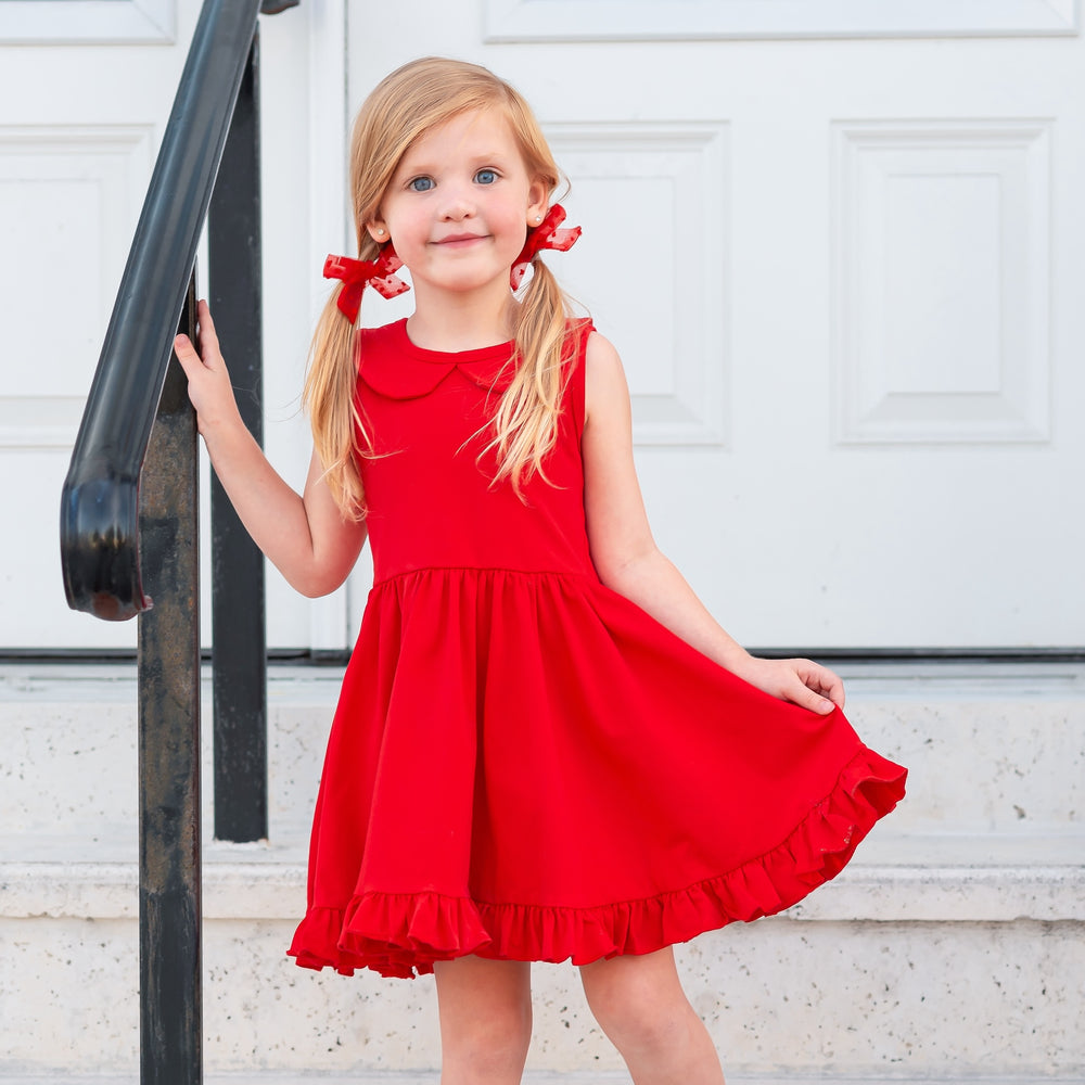 little girl wearing pigtails with red hairbows and bright red tank top style twirl dress