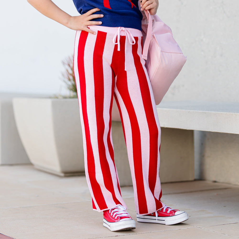 little girl with backpack in red and pink striped sweater pants with adjustable waistband paired with navy bow sweater 