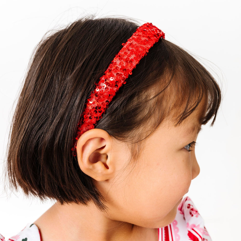 little girl in red sequin headband and matching candy cane twirl dress for Christmas