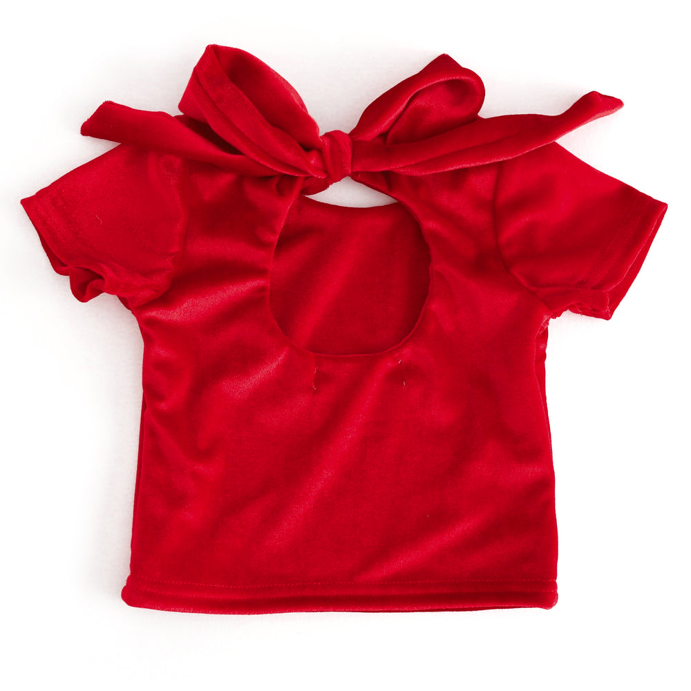 back view of short sleeve red velvet top with keyhole cutout and large velvet bow tied at the top