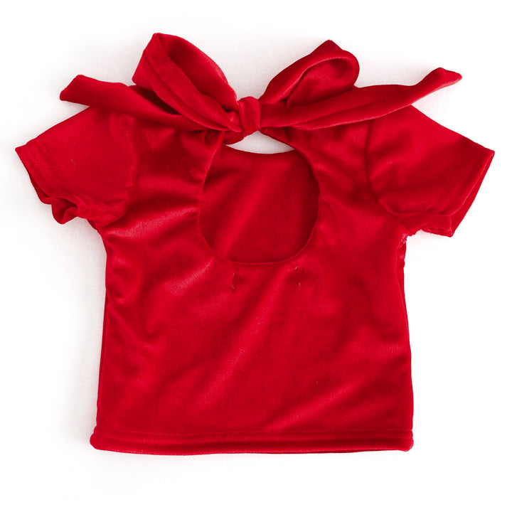 back view of short sleeve red velvet top with keyhole cutout and large velvet bow tied at the top