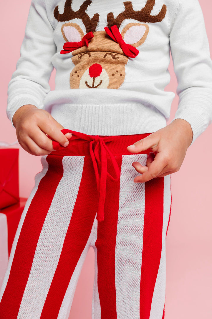 close up of red drawstring waistband of red and white striped Christmas sweater pants paired with white reindeer sweater