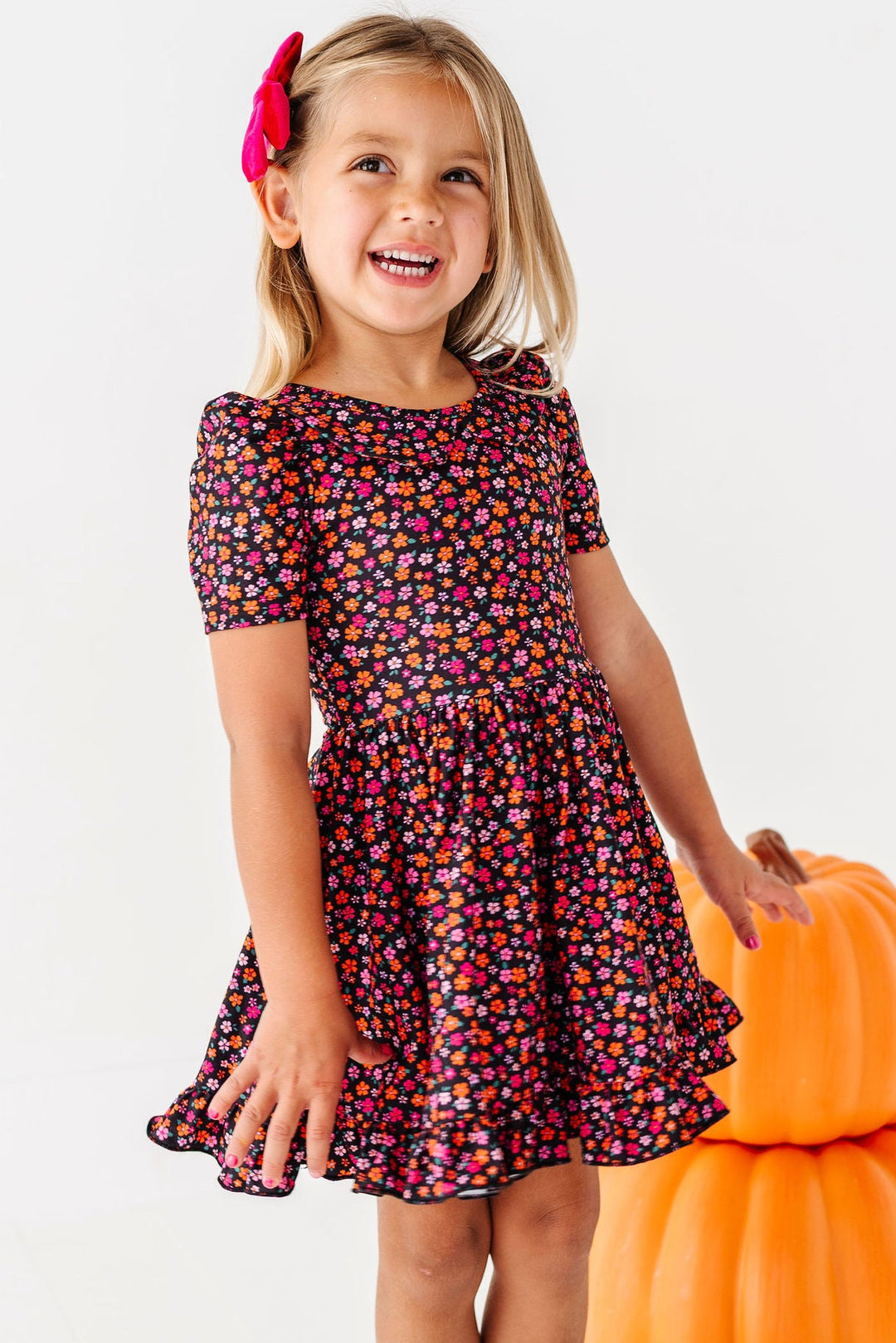 little girl wearing halloween floral dress with matching socks and hair bow