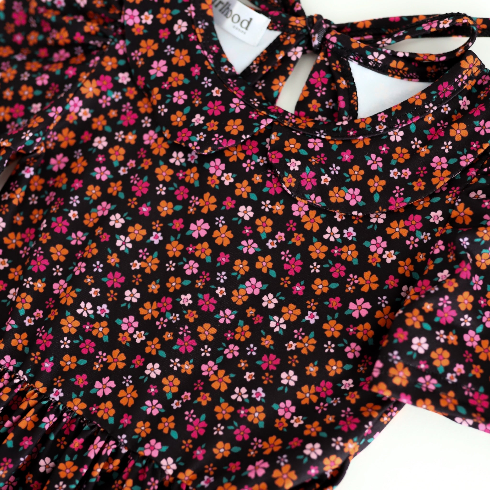 closeup of black collared Halloween twirl dress with tiny orange and pink flower print