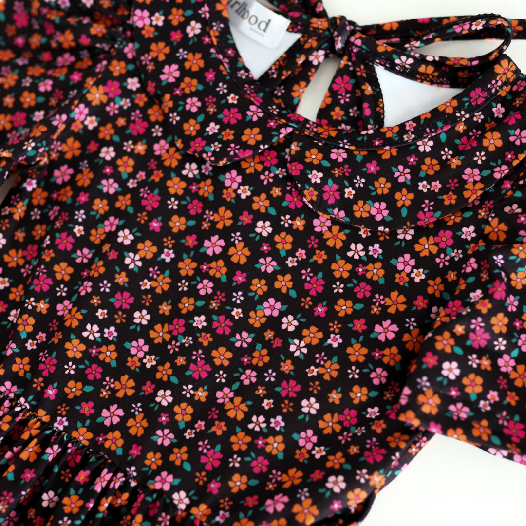 closeup of black collared Halloween twirl dress with tiny orange and pink flower print