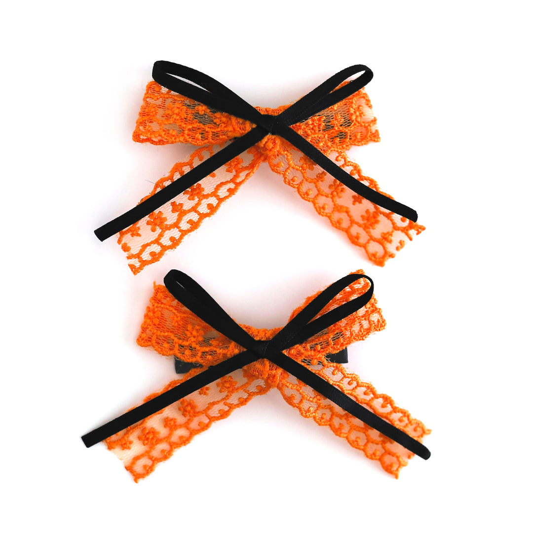 girl's orange lace pigtail bows on clips with thin black ribbon detail for Halloween