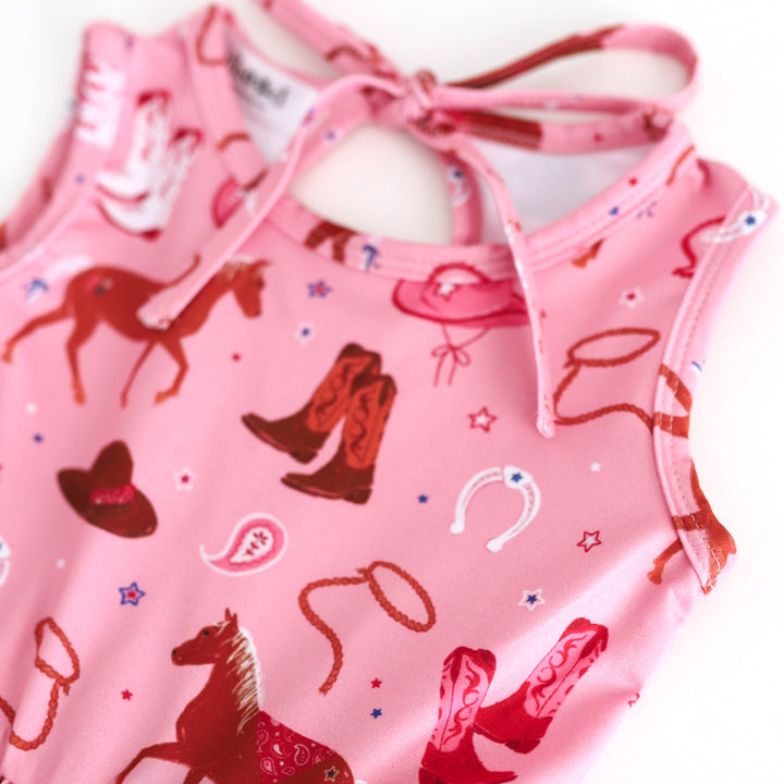 closeup of girls' pink tank dress with cowboy boots, horses and rodeo inspired details