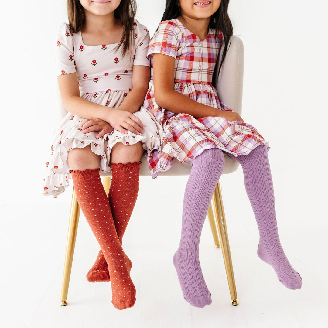 two little girls wearing rust and purple matching outfits for fall