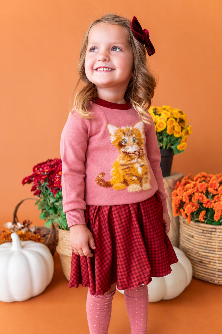 little girl in front if fall flower baskets in rust gingham twirl dress and old rose sweater with cute kitten design