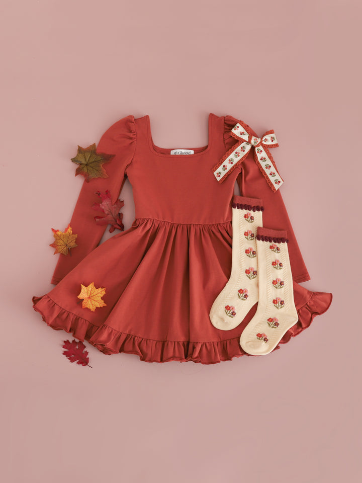 girls' solid rust long sleeve twirl dress paired with matching cream and rust floral knee socks and hair bow