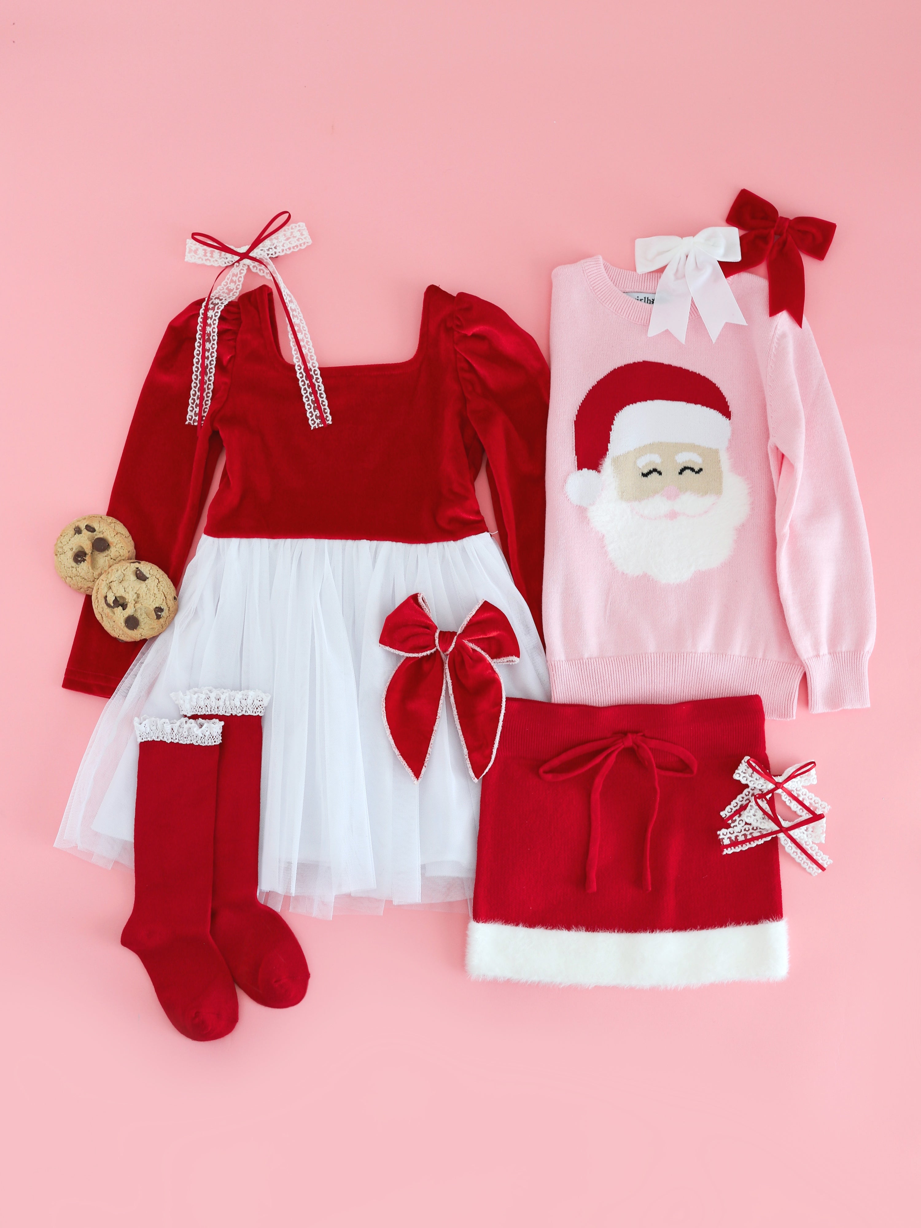 flat lay of Santa inspired velvet tutu dress, sweater, sweater skirt and matching red and white socks and hair bows for Christmas