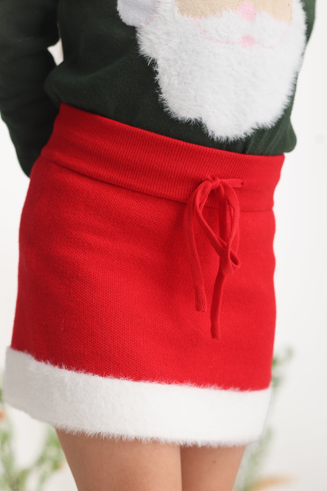 little girl in bright red knit sweater with fluffy white trim and drawstring