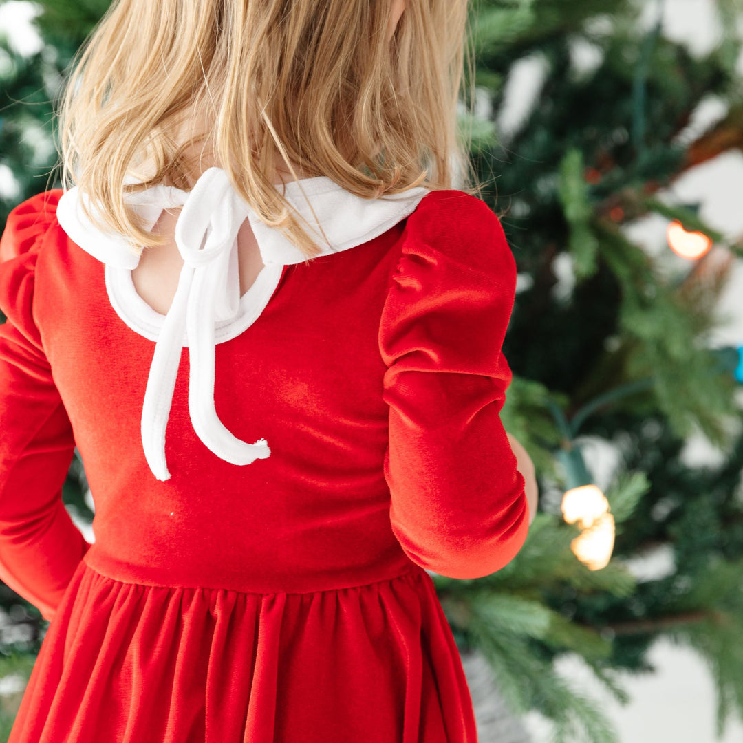 back view of long sleeve red velvet Santa dress with white collar and tie back 