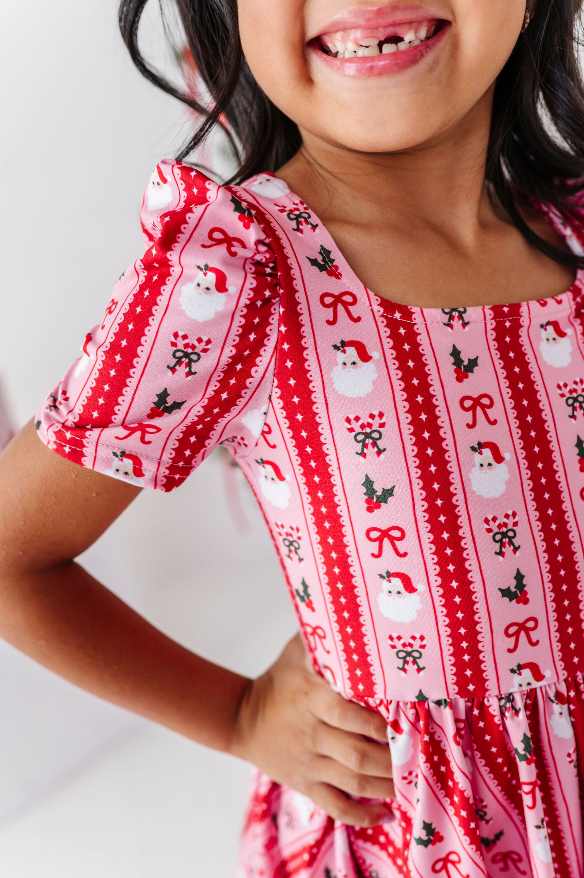 details of christmas wallpaper print dress with santa, holly, candycanes and bows