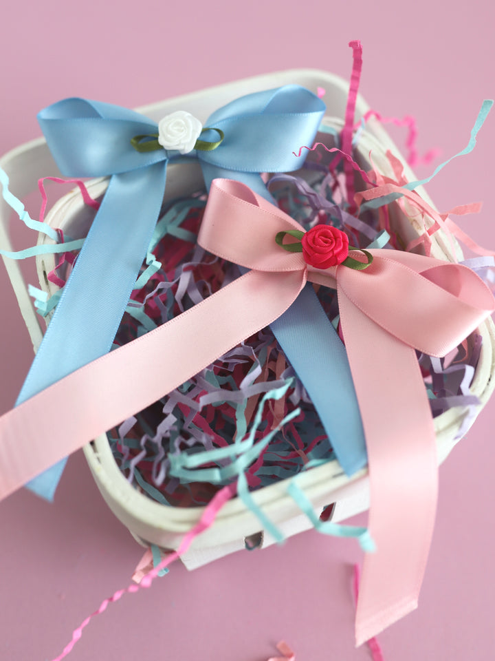 girls' satin hair bows with rosette embellishments at the center in pink and blue styled in Easter basket