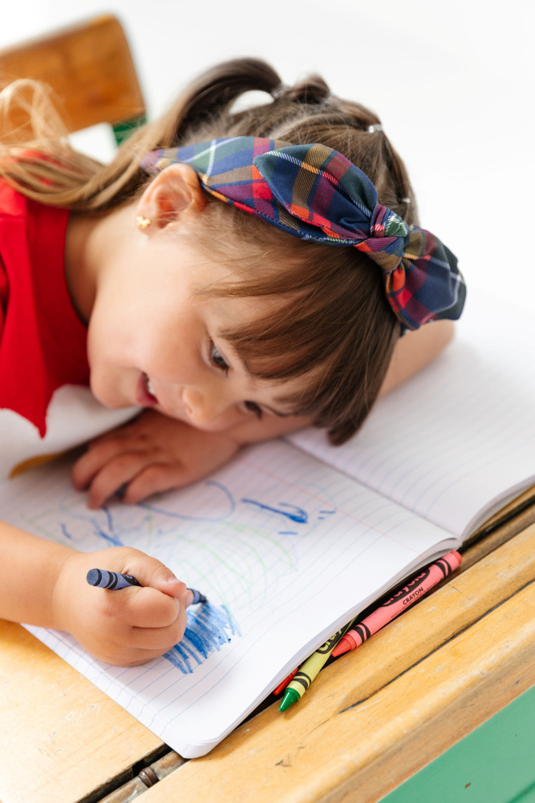 little girl coloring in classic navy plaid headband to match school outfits