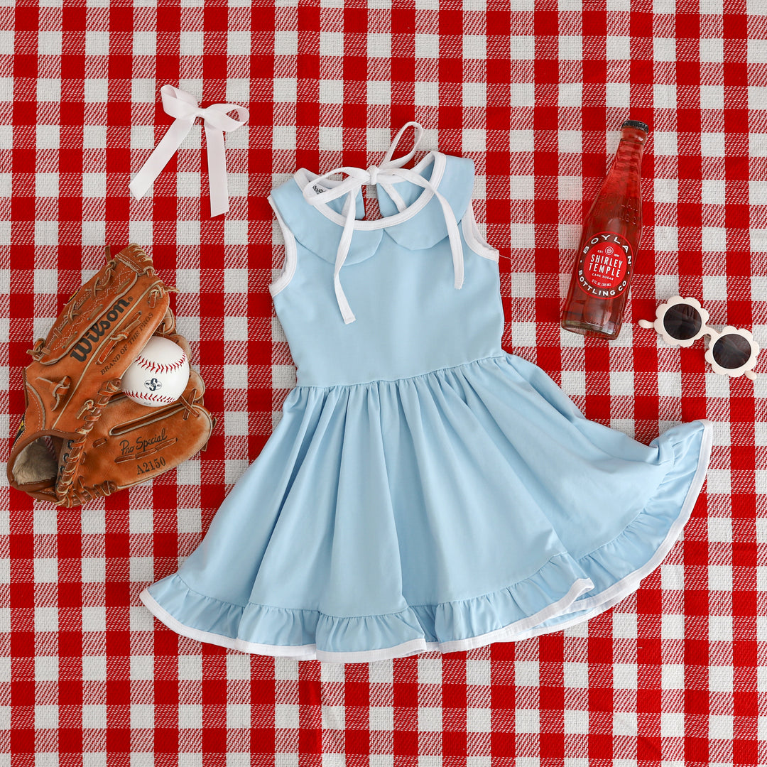 girls light blue collared sleeveless twirl dress styled on red gingham picnic blanket for fourth of July vibes