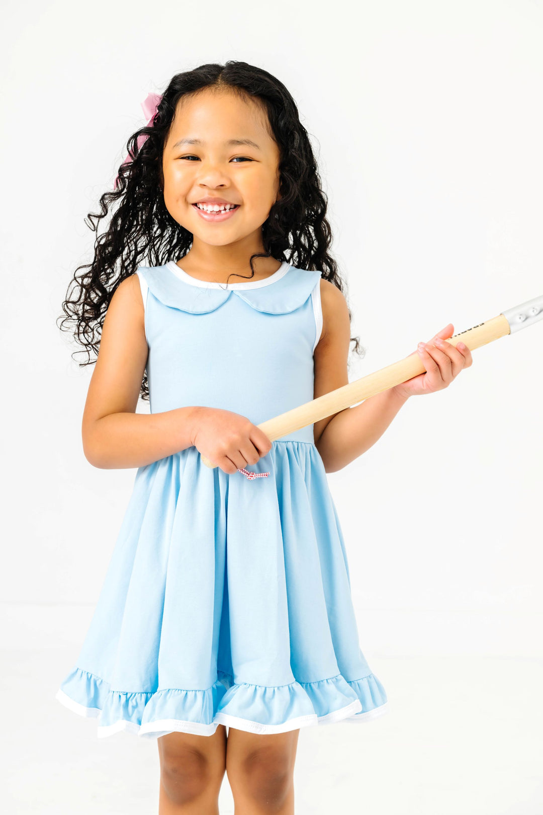 girl holding butterfly net in light blue sleeveless twirl dress with peter pan collar and white trim