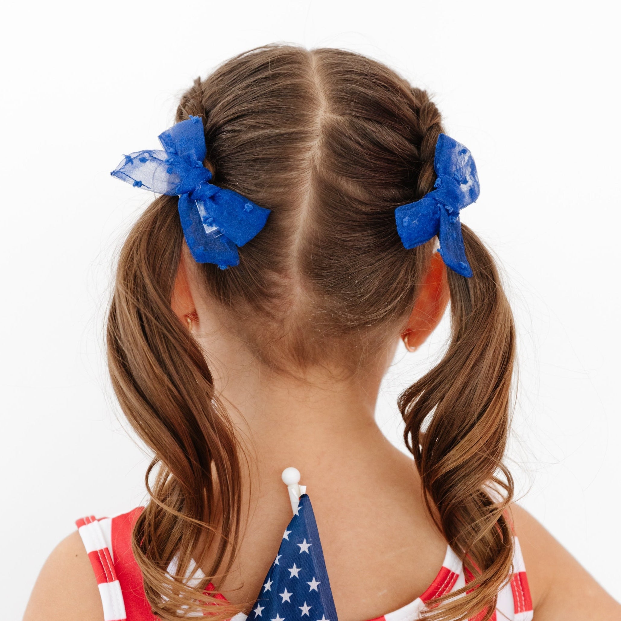 little girl wearing sheer pigtail bows and fourth of july outfit