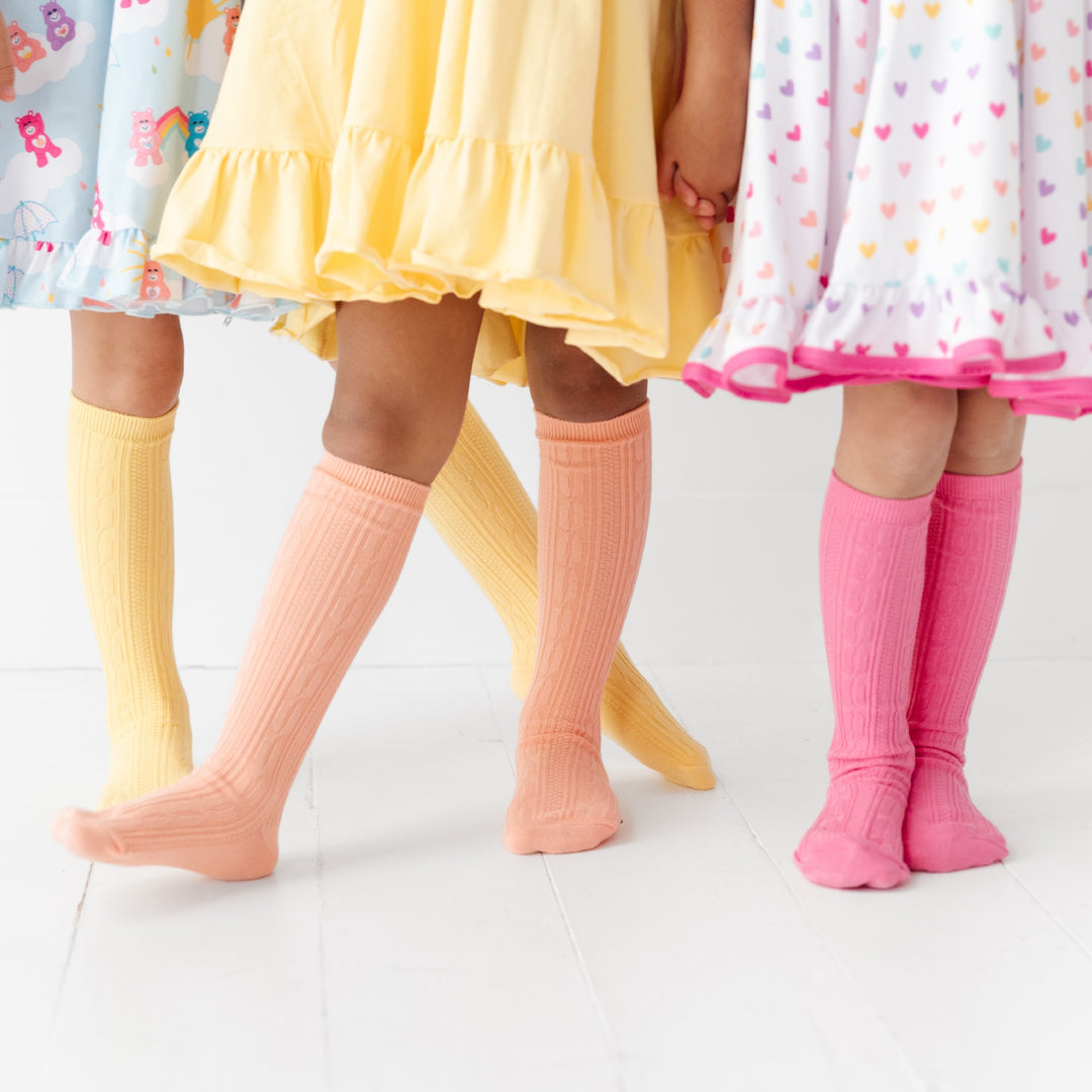 girls wearing spring knee high socks that are pink, peach and yellow
