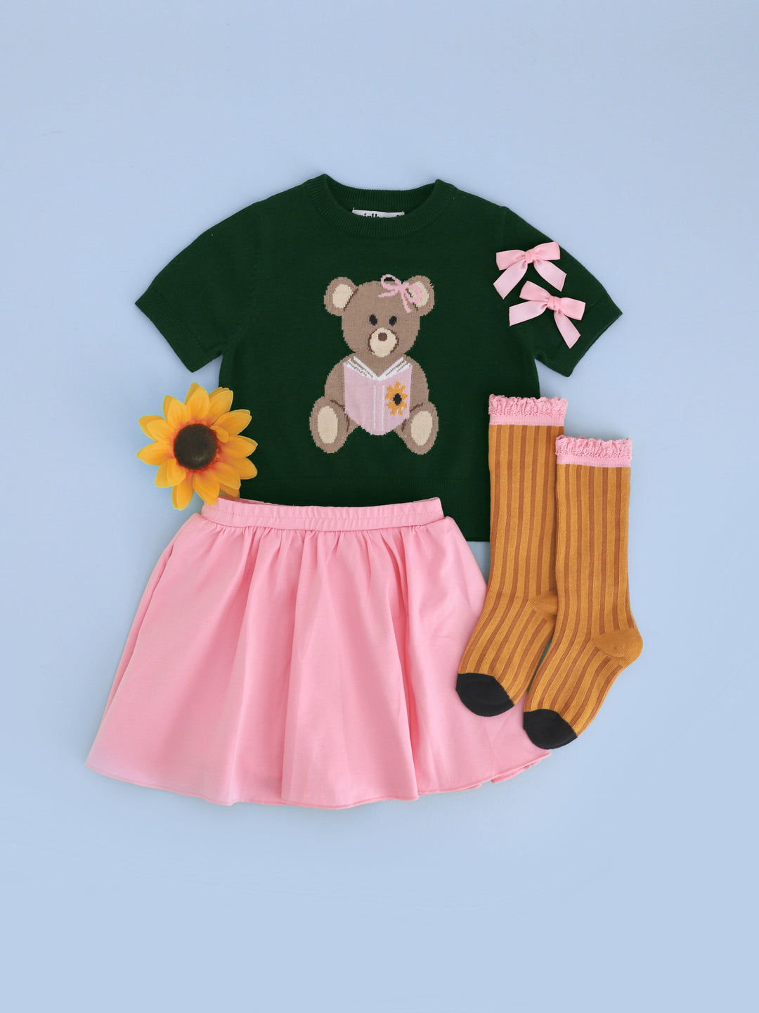 girls' forest green short sleeve knit sweater with bear design paired with pink cotton blend skort, pencil socks and pink satin pigtail bows